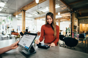 lady completing a sale in a store - WooCommerce Redirect After Checkout